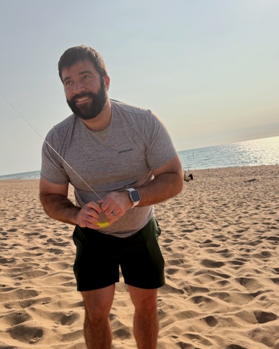 Andi Ruda, founder of Ruda Works, standing on a Lake Michigan beach.